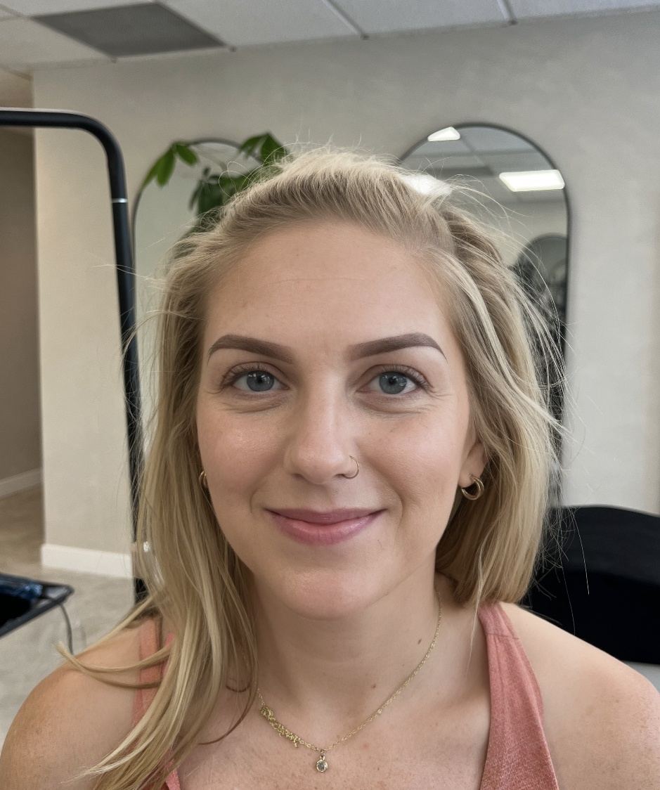 A client with blonde hair, smiling, photographed in the studio at the end of the appointment.