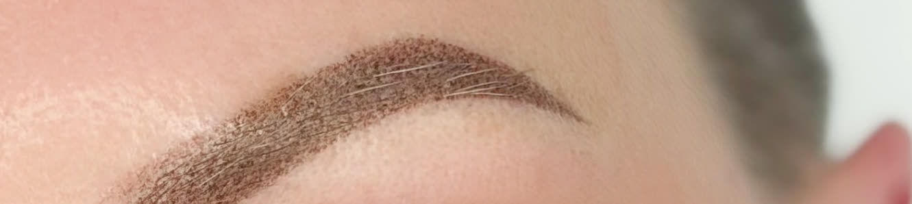 A finished brow with a soft front edge fading into bare skin rather than starting on a hard line.